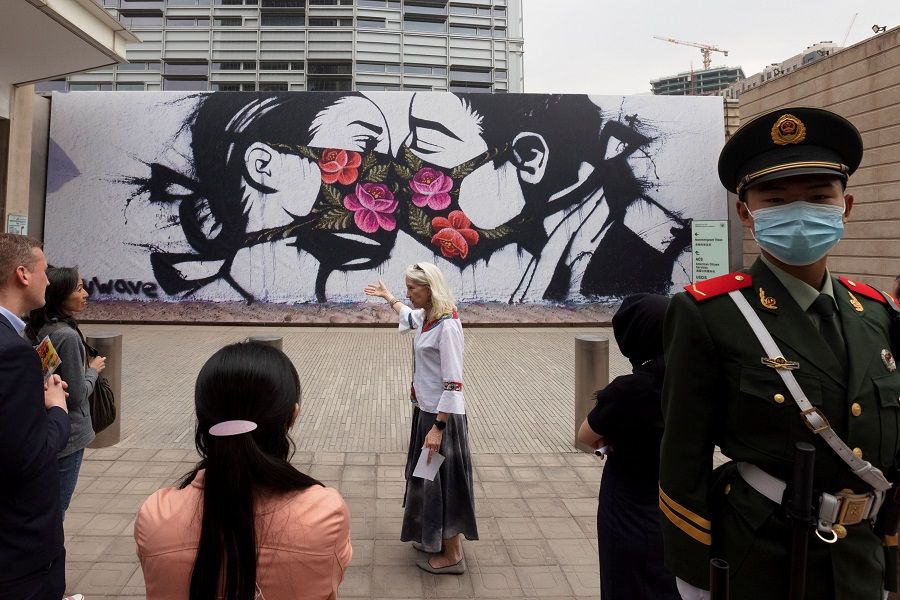 Visitors look at a reproduction of street art by US artist Pony Wave that is part of an exhibition titled "Art for the People" on display at the US Embassy in Beijing, China, 21 April 2021. (Thomas Peter/Reuters)