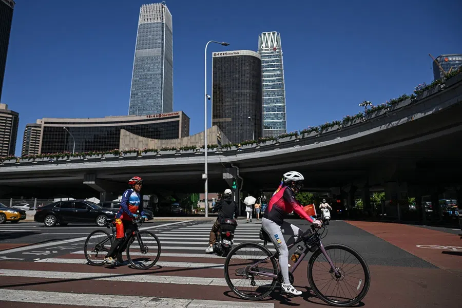 Cyclists ride along a street in the central business district of Beijing on 8 September 2025. (Jade Gao/AFP)