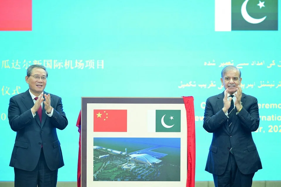 Chinese Premier Li Qiang and Pakistan’s Prime Minister Shehbaz Sharif react after unveiling a plaque to mark the completion of the New Gwadar International Airport, during a ceremony at the Prime Minister’s House in Islamabad, Pakistan, on 14 October 2024.  (Prime Minister’s House/Handout via Reuters)