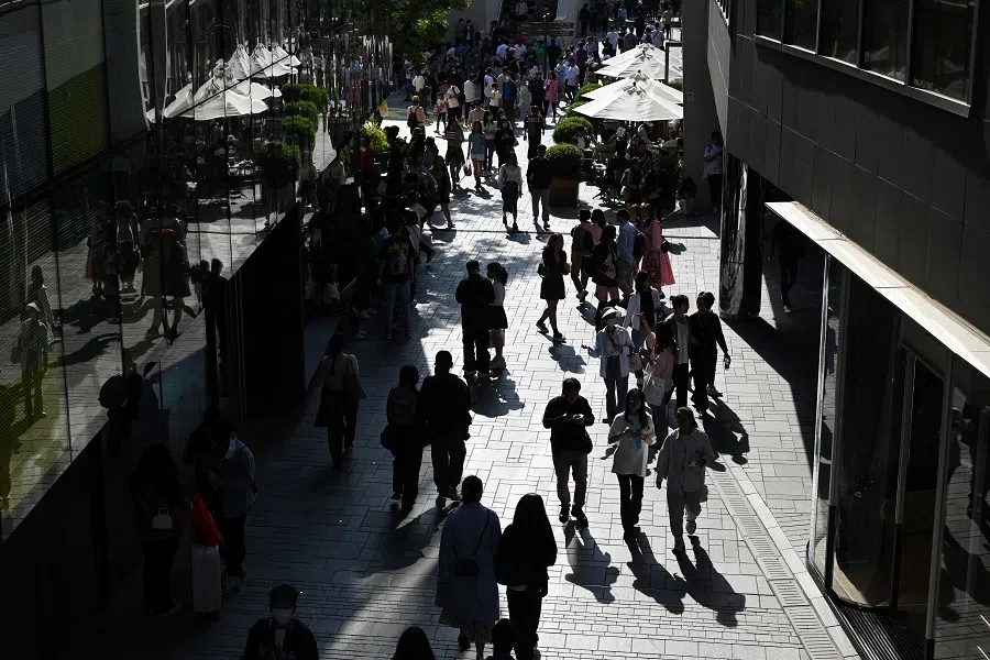 People walk through a shopping mall in Beijing, China, on 30 April 2023. (Greg Baker/AFP)