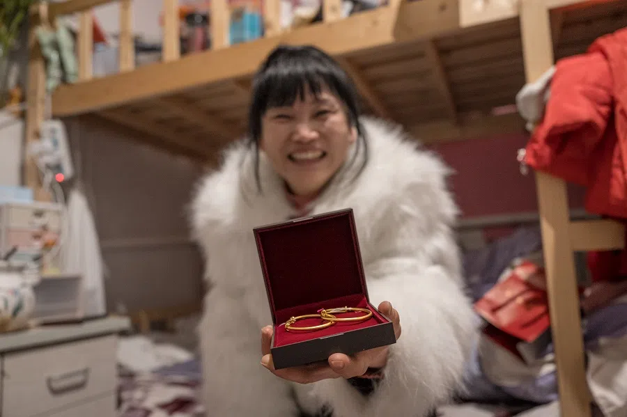 Sister Chen shows a pair of gold bracelets she bought for her grandchild, weighing over 28 grams and costing over 20,000 RMB.