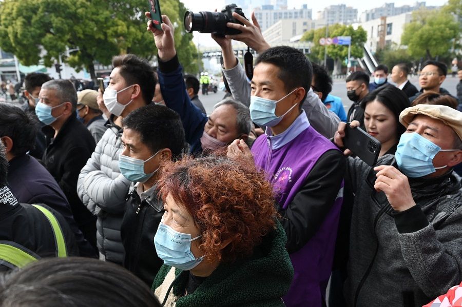 People try to get a view of former Taiwan President Ma Ying-jeou as he arrives to visit the Nanjing Massacre Memorial Hall in Nanjing, Jiangsu province, China, on 29 March 2023. (Greg Baker/AFP)