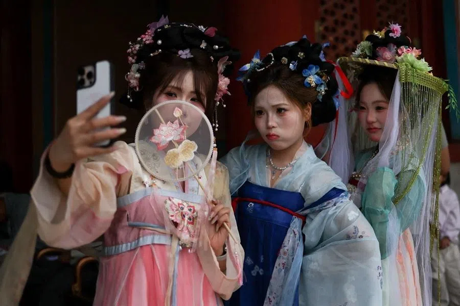 Women wearing costumes pose for pictures as they visit the Forbidden City, on the first day of the five-day Labour Day holiday in Beijing, China, on 1 May 2026.