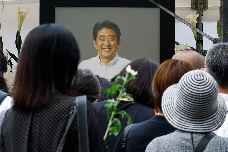 People gather to offer flowers at Zojoji Temple, where the funeral of late former Japanese prime minister Shinzo Abe, who was shot while campaigning for a parliamentary election, will be held, in Tokyo, Japan, 12 July 2022. (Kim Kyung-Hoon/Reuters)
