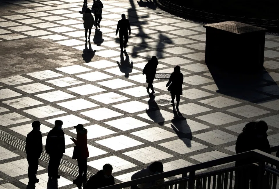 People are seen in silhouette on a street on a winter day in Beijing, following the coronavirus disease (COVID-19) outbreak, China, 21 December 2020. (Tingshu Wang/REUTERS)