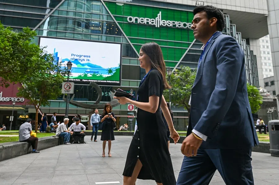 People walk out during lunchtime at Raffles Place financial district in Singapore on 26 June 2023. (Roslan Rahman/AFP)