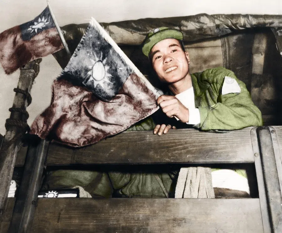 Defecting volunteer troops going around Taipei in army trucks, holding flags stained with their own blood, 1954.