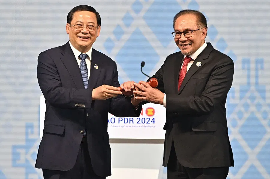 Malaysia’s Prime Minister Anwar Ibrahim (right) is given the ceremonial gavel by Laos’ Prime Minister Sonexay Siphandone during the closing ceremony of the 44th and 45th Association of Southeast Asian Nations (ASEAN) Summits, with Malaysia set to take over the ASEAN chairmanship in 2025, in Vientiane, on 11 October 2024. (Tang Chhin Sothy/AFP)