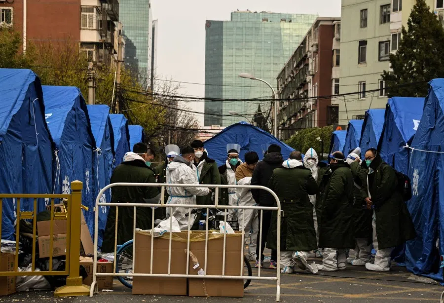 Security personnel wearing Personal Protective Equipment (PPE) are seen near a residential area under lockdown due to Covid-19 coronavirus restrictions in Beijing on 22 November 2022. (Noel Celis/AFP)