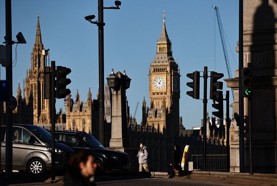 A pedestrian passes a road junction on the south bank of the River Thames, as The Elizabeth Tower, commonly known by the name of the clock's bell, "Big Ben", at the Palace of Westminster, home to the Houses of Parliament, is seen in the background in central London on 15 January 2024. (Henry Nicholls/AFP)