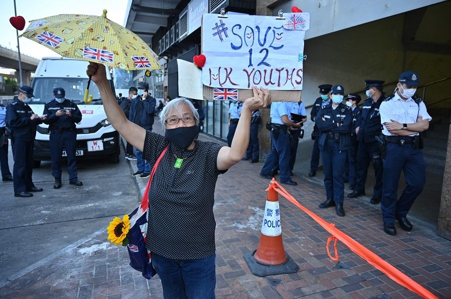 Protester Alexandra Wong dubbed "Grandma Wong" holds up signs outside China's Liaison Office in Hong Kong on 28 December 2020 calling on China to free a group of Hong Kong democracy activists facing trial in China, after they attempted to flee the territory by speedboat to Taiwan. (Peter Parks/AFP)