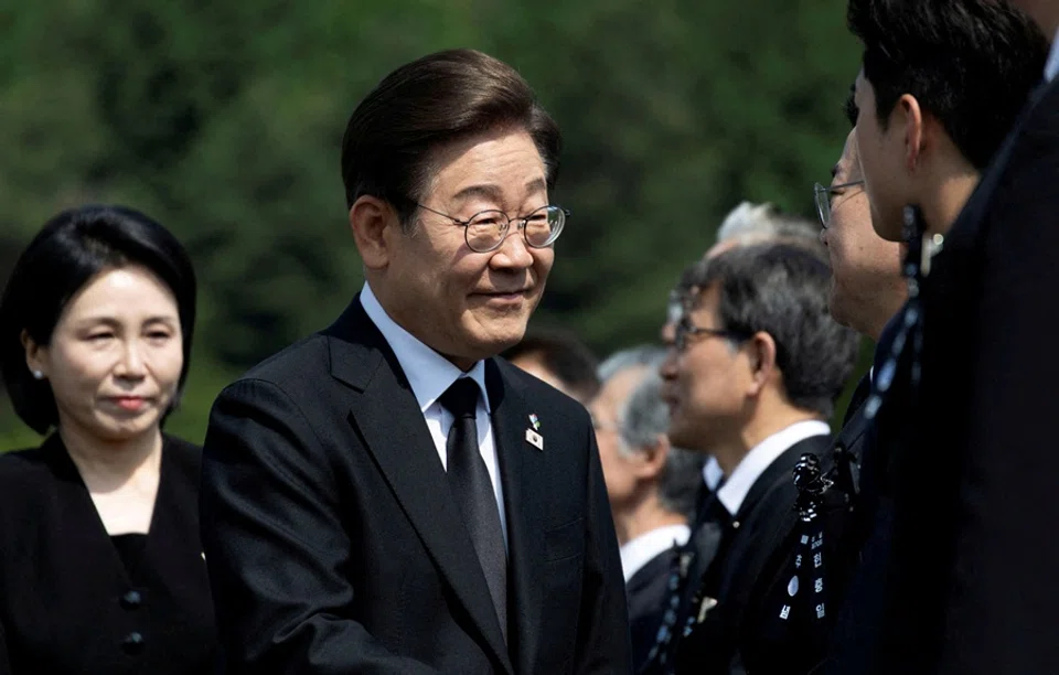 South Korean President Lee Jae-myung (centre) and his wife Kim Hye-Kyung (left) arrive for a ceremony to mark the 70th Memorial Day at the Seoul National Cemetery in Seoul, South Korea, on 6 June 2025.  (Jeon Heon-Kyun/Pool via Reuters)