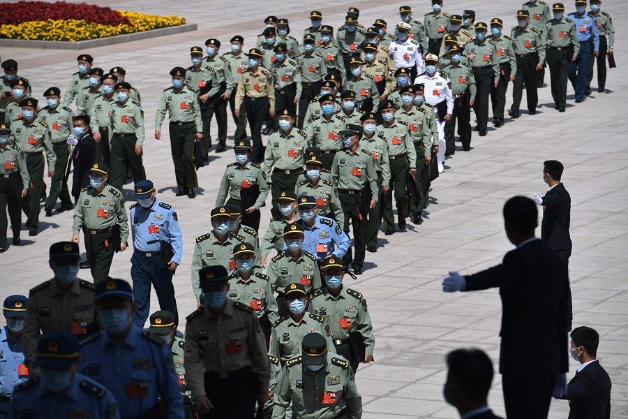 Military delegates arrive for the closing session of the National People's Congress at the Great Hall of the People in Beijing on 28 May 2020. (Nicolas Asfouri/AFP)