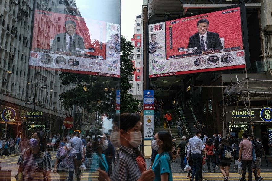 A news report on Chinese President Xi Jinping's speech in the city of Shenzhen is shown on a public screen in Hong Kong, 14 October 2020. (Roy Liu/Bloomberg)