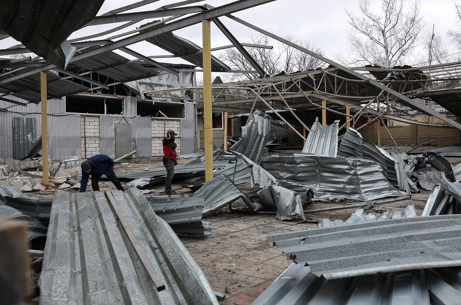 Workers clean the debris of a bus station destroyed by Russian shelling in the Ukrainian town of Kupiansk, Kharkiv region, on 7 March 2023. (Anatolii Stepanov/AFP)