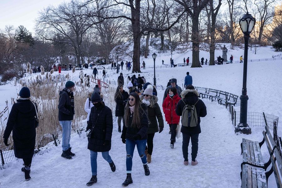 People walk on a snow-covered path in Central Park after a winter snow storm on 30 January 2022 in New York City, US. (Yuki Iwamura/AFP)