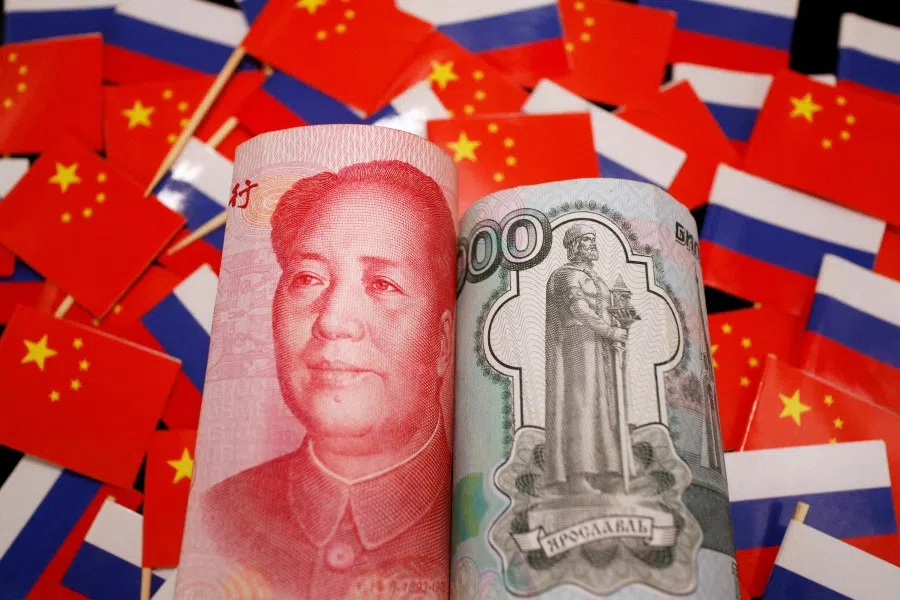 Banknotes of Chinese RMB and Russian rouble are seen amid flags of China and Russia in this illustration picture taken 15 September 2022. (Florence Lo/Reuters)