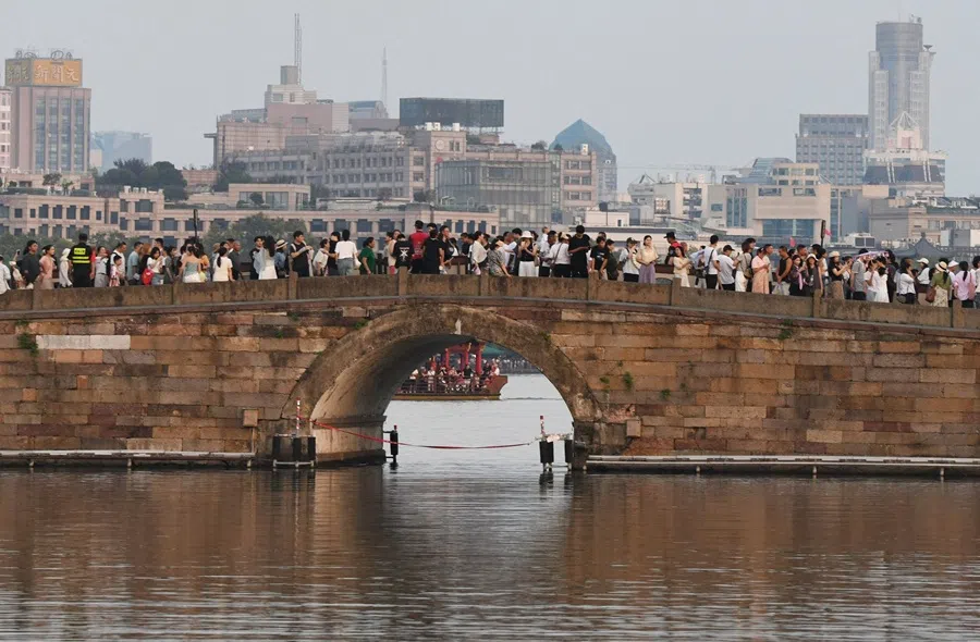 People crowd the Broken Bridge on West Lake in Hangzhou, in China’s eastern Zhejiang province on 6 October 2025. (AFP)