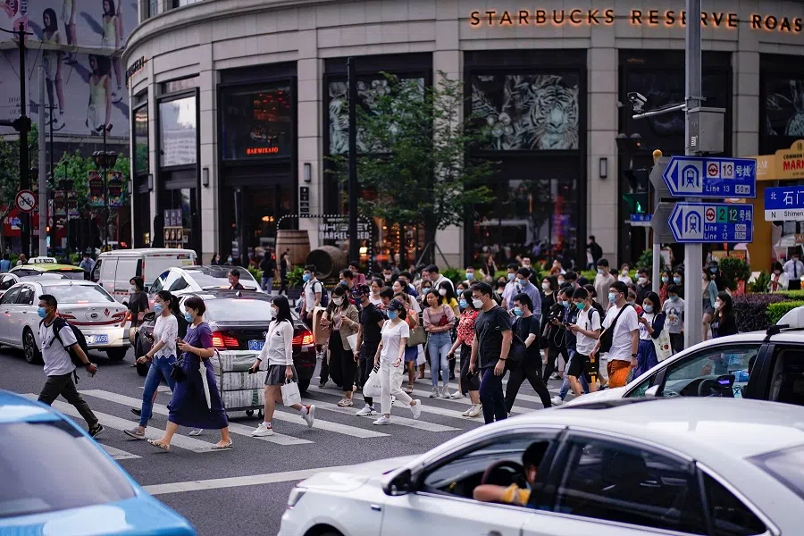 People wearing face masks are seen on a street in Shanghai, following the coronavirus disease outbreak, in China, on 19 June 2020. (Aly Song/Reuters)