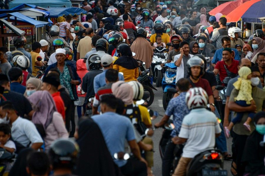 People gather in a street market to break their fast during the holy month of Ramadan in Banda Aceh on 14 April 2021. (Chaideer Mahyuddin/AFP)
