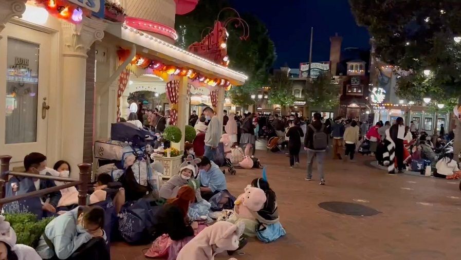 People sit inside the Shanghai Disney Resort amid the Covid-19 outbreak, in Shanghai, China, 31 October 2022 in this screen grab from a video obtained by Reuters.