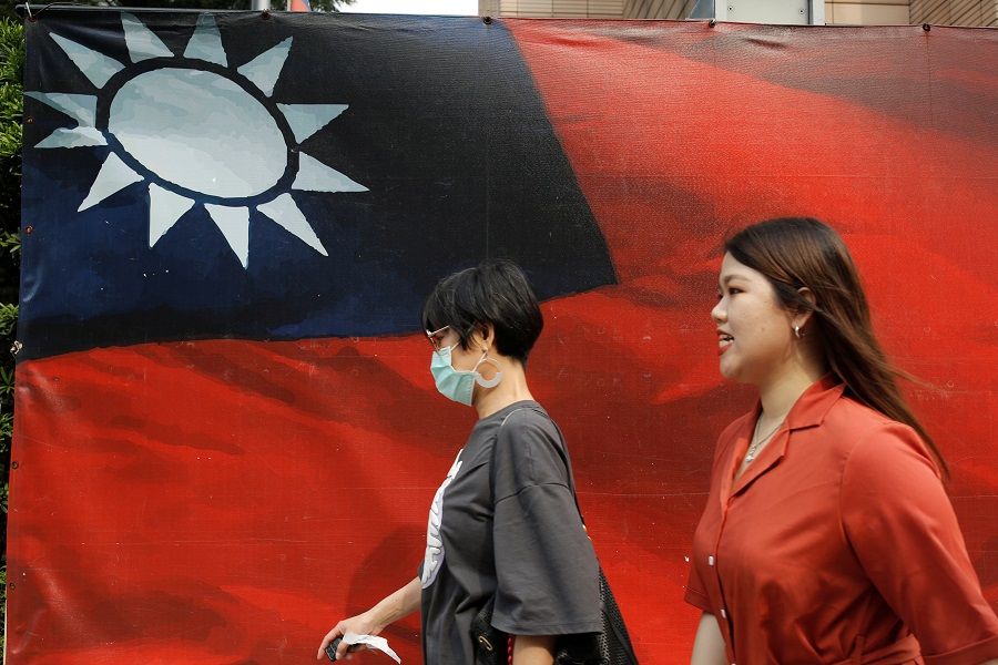 People walk past a Taiwan flag in Taipei, Taiwan, 10 August 2020. (Ann Wang/Reuters)
