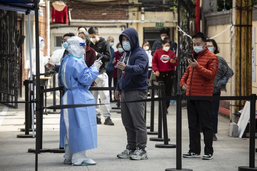 Residents show their health codes on mobile phones before taking part in a round of Covid-19 testing during a lockdown in Shanghai, China, on 18 April 2022. (Qilai Shen/Bloomberg)