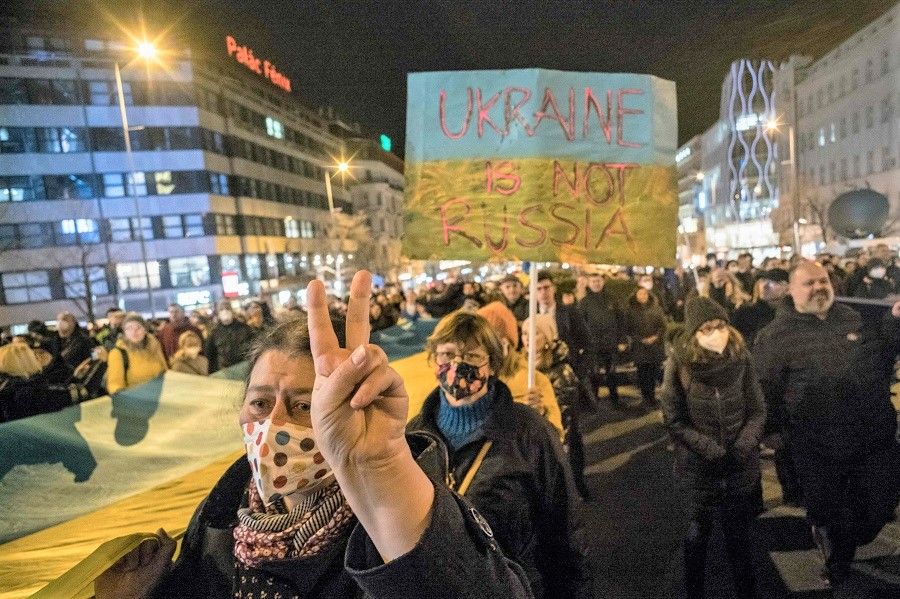 Pro-Ukraine demonstrators display placards and Ukrainian flags during a demonstration in support to Ukraine at the Wenceslas Square in Prague, Czech Republic, on 22 February 2022 following Russia's recognition of eastern Ukrainian separatists. (Michal Cizek/AFP)