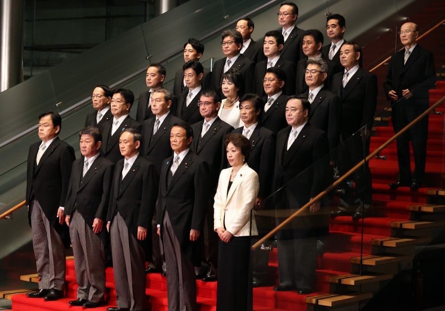 Yoshihide Suga, Japan's prime minister, front row center, poses for a group photograph with his new cabinet members at his official residence in Tokyo, Japan, 16 September 2020. (Yoshikazu Tsuno/Bloomberg)