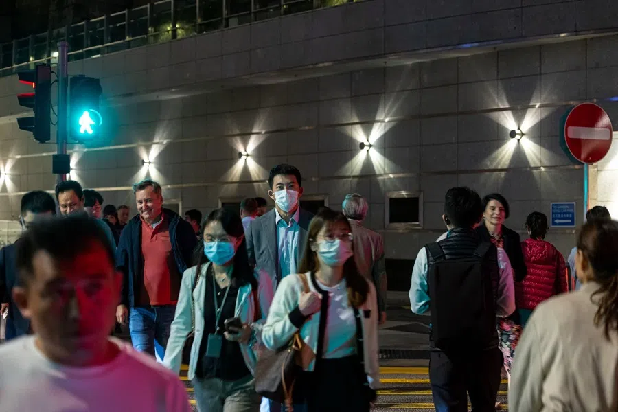 Pedestrians cross a road in the Central district in Hong Kong, China, on 20 November 2023. (Paul Yeung/Bloomberg)