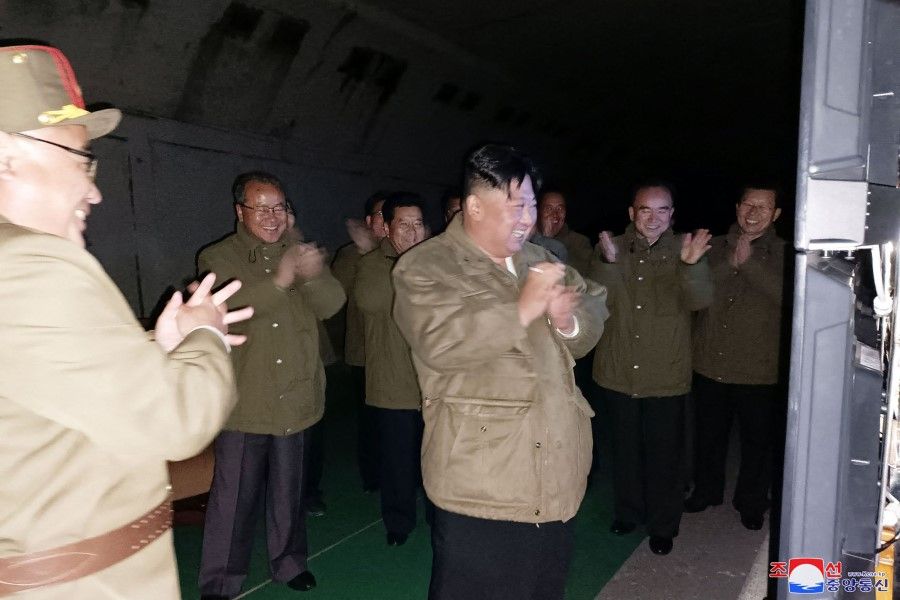 This picture taken on 12 October 2022 and released from North Korea's official Korean Central News Agency (KCNA) on 13 October 2022 shows North Korean leader Kim Jong Un (centre) reacting after a test-fire of long-range strategic cruise missiles conducted by the Korean People's Army Tactical Nuclear Operation Unit at an undisclosed location. (KCNA via KNS/AFP)