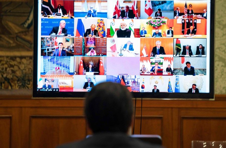 This handout photo by the press office of Palazzo Chigi shows Italian Prime Minister, Giuseppe Conte (L) taking part in a video conference as part of an extraordinary meeting of G20 leaders, from the Chigi Palace in Rome, March 26, 2020. Conte is blocking a joint response that EU leaders are trying to put together to the coronavirus crisis, an Italian government source said on March 26. (Handout / Palazzo Chigi press office / AFP)