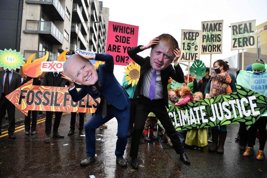 Climate activists wear the masks of US President Joe Biden (left) and British Prime Minister Boris Johnson at a protest action in Glasgow on 12 November 2021, during the COP26 UN Climate Change Conference. (Ben Stansall/AFP)