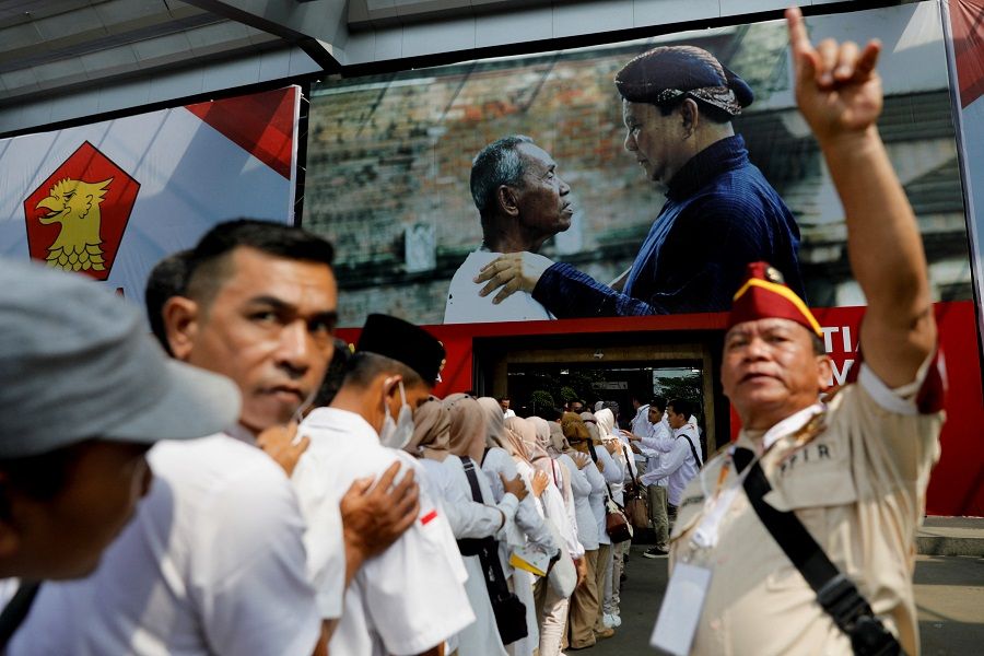 Gerindra Party members queue to enter the venue of the national meeting of its leaders as a picture of Prabowo Subianto is seen in the background, in Bogor, Indonesia, 12 August 2022. (Willy Kurniawan/Reuters)