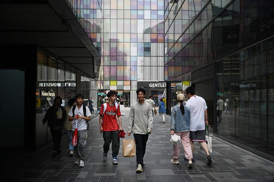 People walk through a shopping mall in Beijing, China, on 5 May 2024. (Greg Baker/AFP)