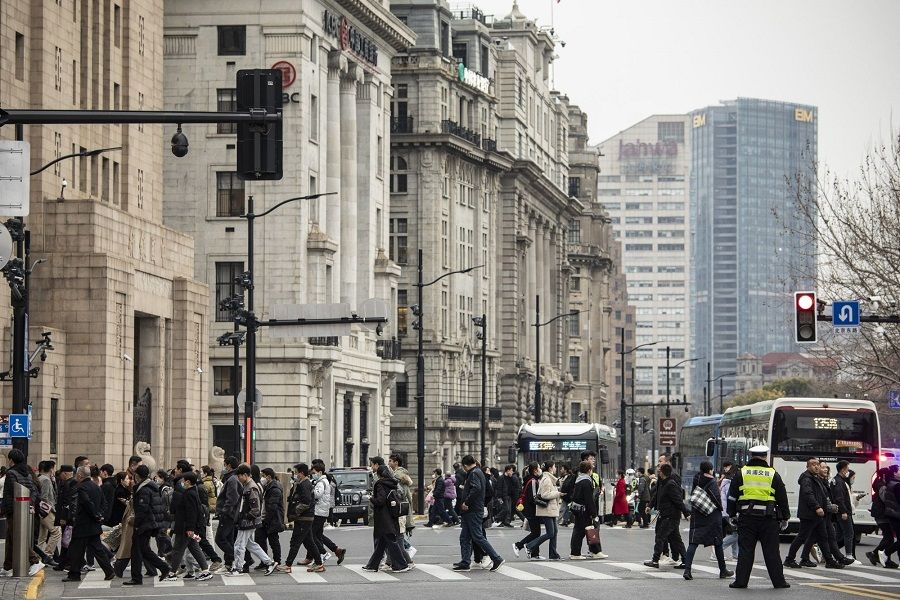 Pedestrians cross a road near the Bund in Shanghai, China, on 28 February 2023. (Qilai Shen/Bloomberg)