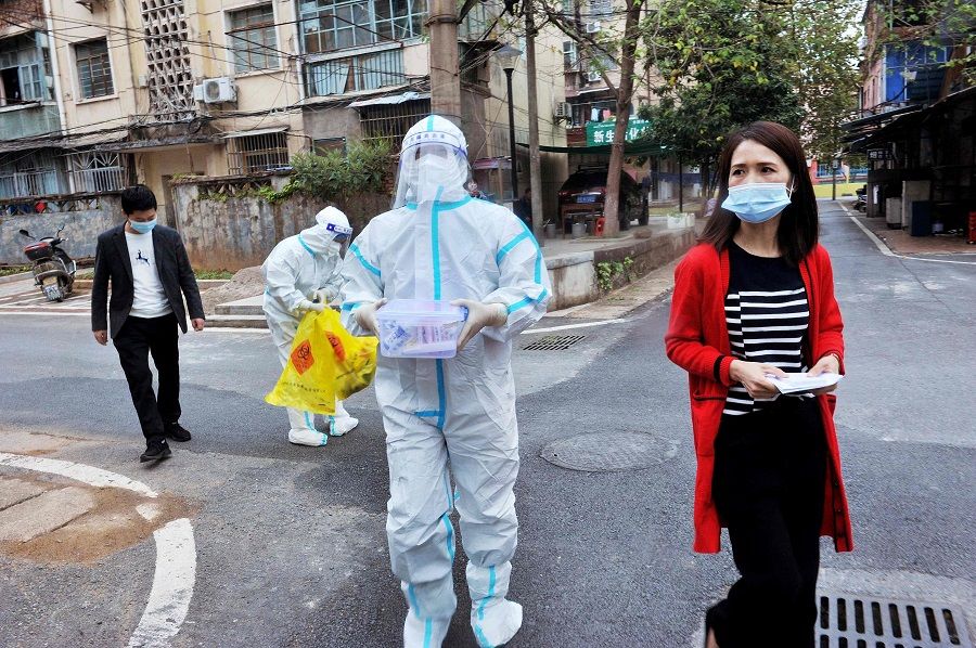 Officials and medical workers prepare to conduct Covid-19 coronavirus tests on residents isolating at home following the recent coronavirus outbreak in Dexing, Jiangxi province, China, on 3 November 2021. (AFP)