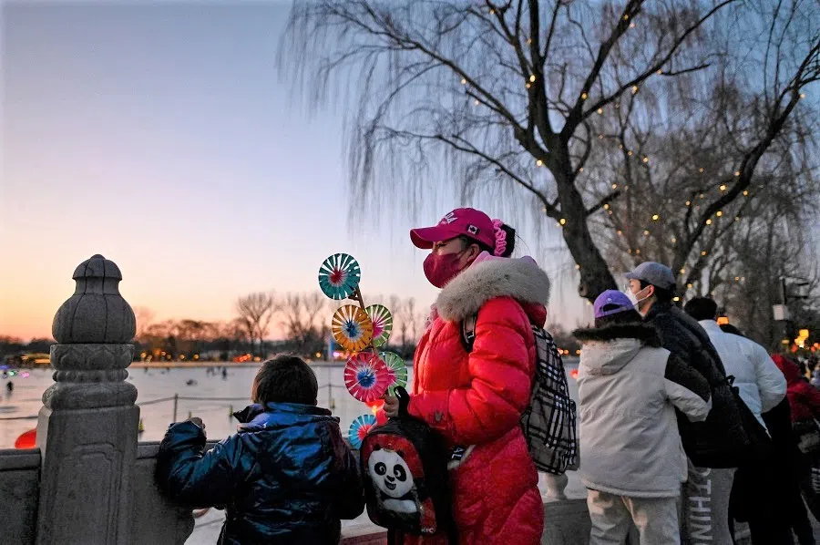 A woman holding a pinwheel during sunset in Beijing, China, on 2 February 2022. (Jade Gao/AFP)