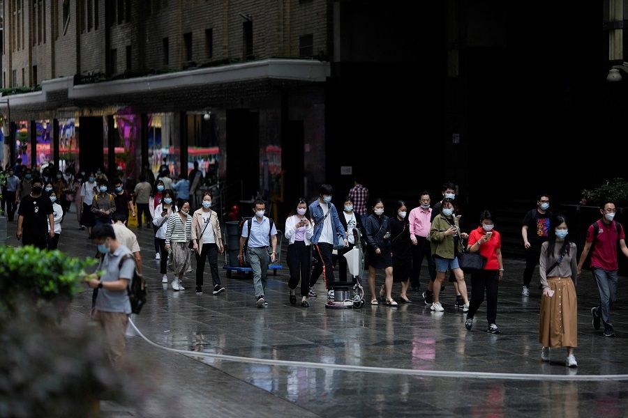 People wearing protective face masks walk on a street in Shanghai, China, 28 September 2022. (Aly Song/Reuters)