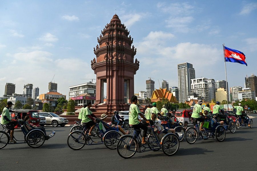 People ride rickshaws, locally known as "cyclo", along a street near the the Independence Monument in Phnom Penh, Cambodia on 16 February 2024. (Tang Chhin Sothy/AFP)