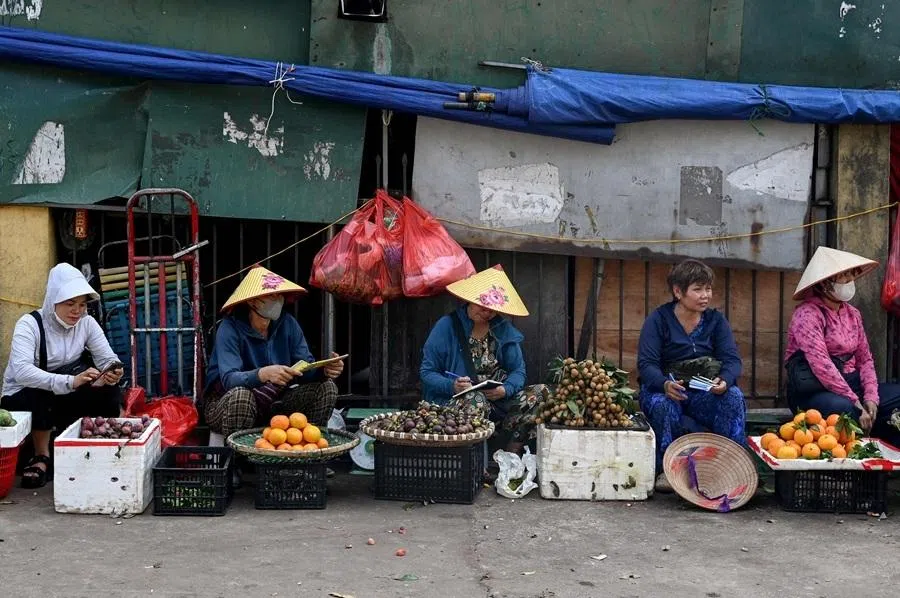 Fruit vendors wait for customers in Hanoi on 4 June 2026.