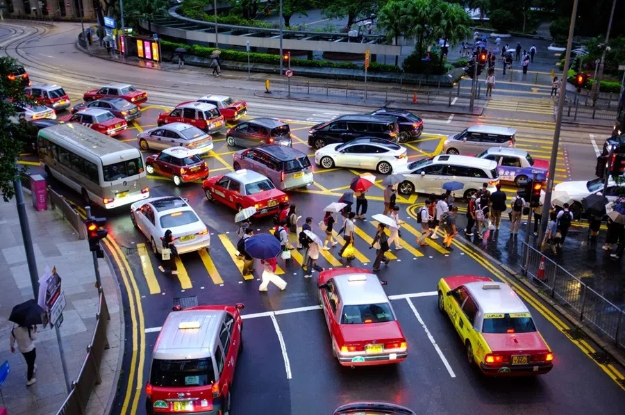 Commuters use umbrellas to shelter from the rain as they cross a road in the Central district in Hong Kong, on 29 July 2026.