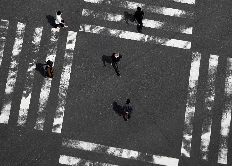 Passersby are seen at a pedestrian crossing in the Ginza shopping district in Tokyo, Japan, on 7 April 2020.