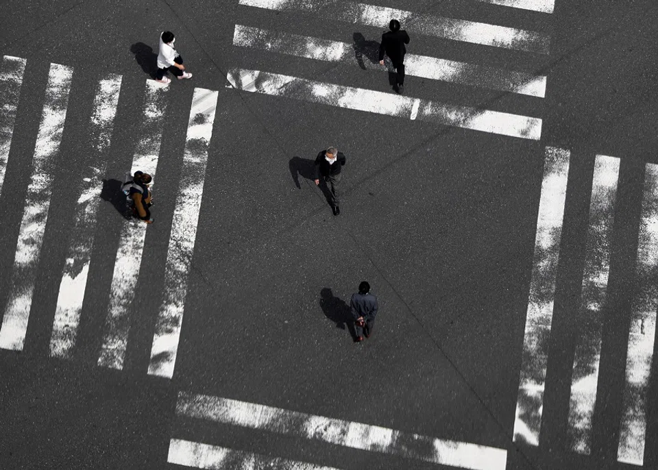 Passersby are seen at a pedestrian crossing in the Ginza shopping district in Tokyo, Japan, on 7 April 2020. (Issei Kato/Reuters)