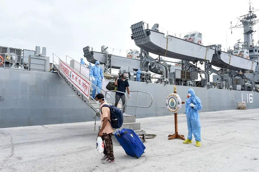 In this handout photograph taken by the Indian Press Information Bureau (PIB), Defence Wing, and released on 11 June 2020, Indian nationals previously stranded in Iran arrive with the Indian Naval Ship (INS) Shardul at Porbandar, some 400 kms from Ahmedabad, as part of a repatriation effort due to the Covid-19 coronavirus. (Handout/PIB Defence Wing/AFP)