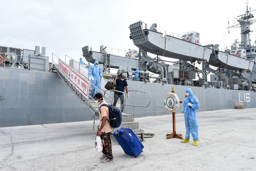 In this handout photograph taken by the Indian Press Information Bureau (PIB), Defence Wing, and released on 11 June 2020, Indian nationals previously stranded in Iran arrive with the Indian Naval Ship (INS) Shardul at Porbandar, some 400 kms from Ahmedabad, as part of a repatriation effort due to the Covid-19 coronavirus. (Handout/PIB Defence Wing/AFP)