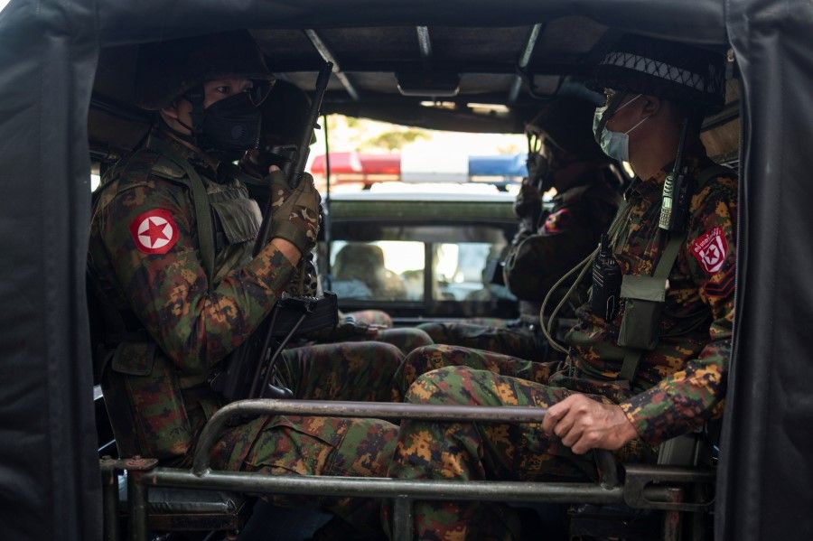 Myanmar soldiers sit inside a vehicle as they guard in front of a Hindu temple in the downtown area in Yangon, Myanmar, 2 February 2021. (Stringer/REUTERS)