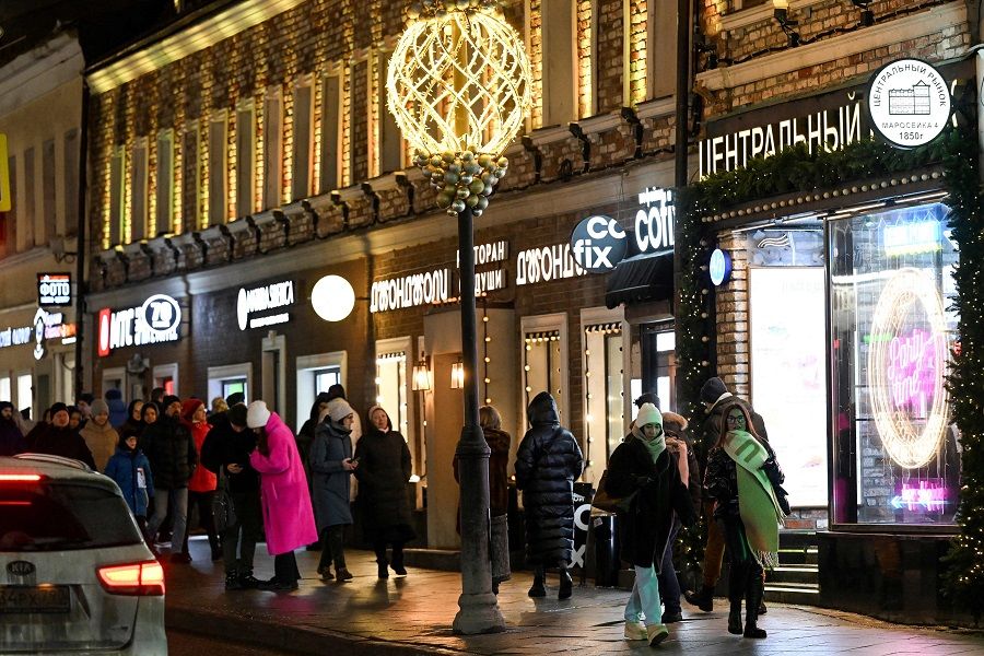 People walk on a street with shops and restaurants in central Moscow, Russia, on 4 February 2023. (Kirill Kudryavtsev/AFP)