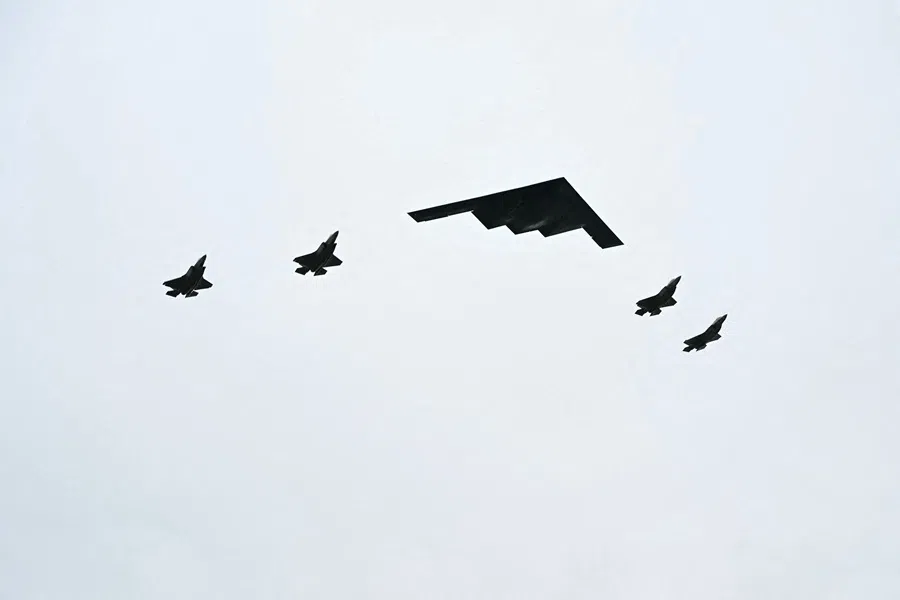 A B-2 bomber (centre) and four F-35 fighter jets fly overhead as US President Donald Trump greets Russian President Vladimir Putin on the tarmac after they arrived at Joint Base Elmendorf-Richardson in Anchorage, Alaska, on 15 August 2025. (Andrew Caballero-Reynolds/AFP)