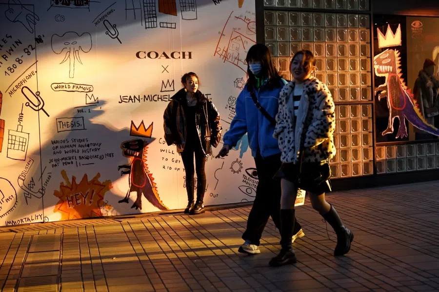 A woman wears a face mask as she walks in the Tai Koo Li shopping centre, following the outbreak of the coronavirus disease (COVID-19), in Beijing, 4 December 2020. (Thomas Peter/Reuters)
